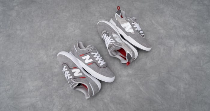 Side view of two grey New Balance shoes.